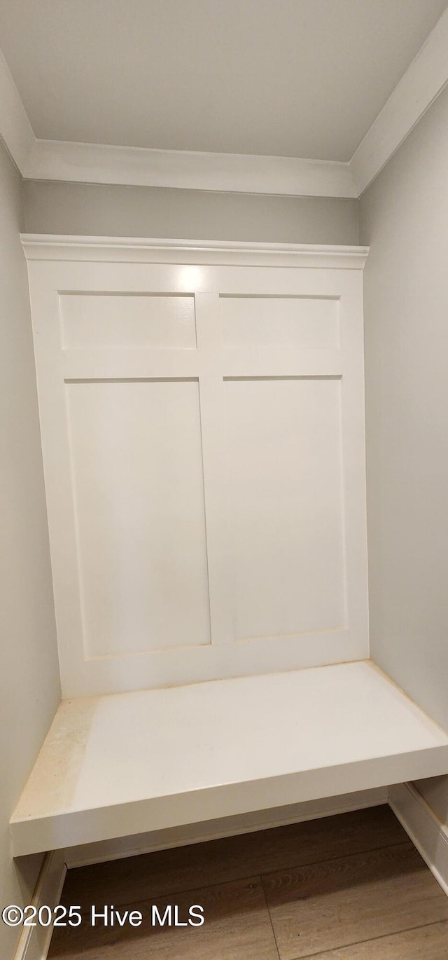 mudroom with wood finished floors and crown molding