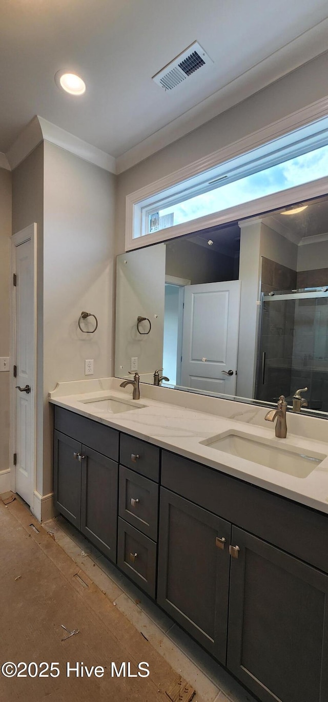 bathroom featuring crown molding, visible vents, a sink, and a shower stall