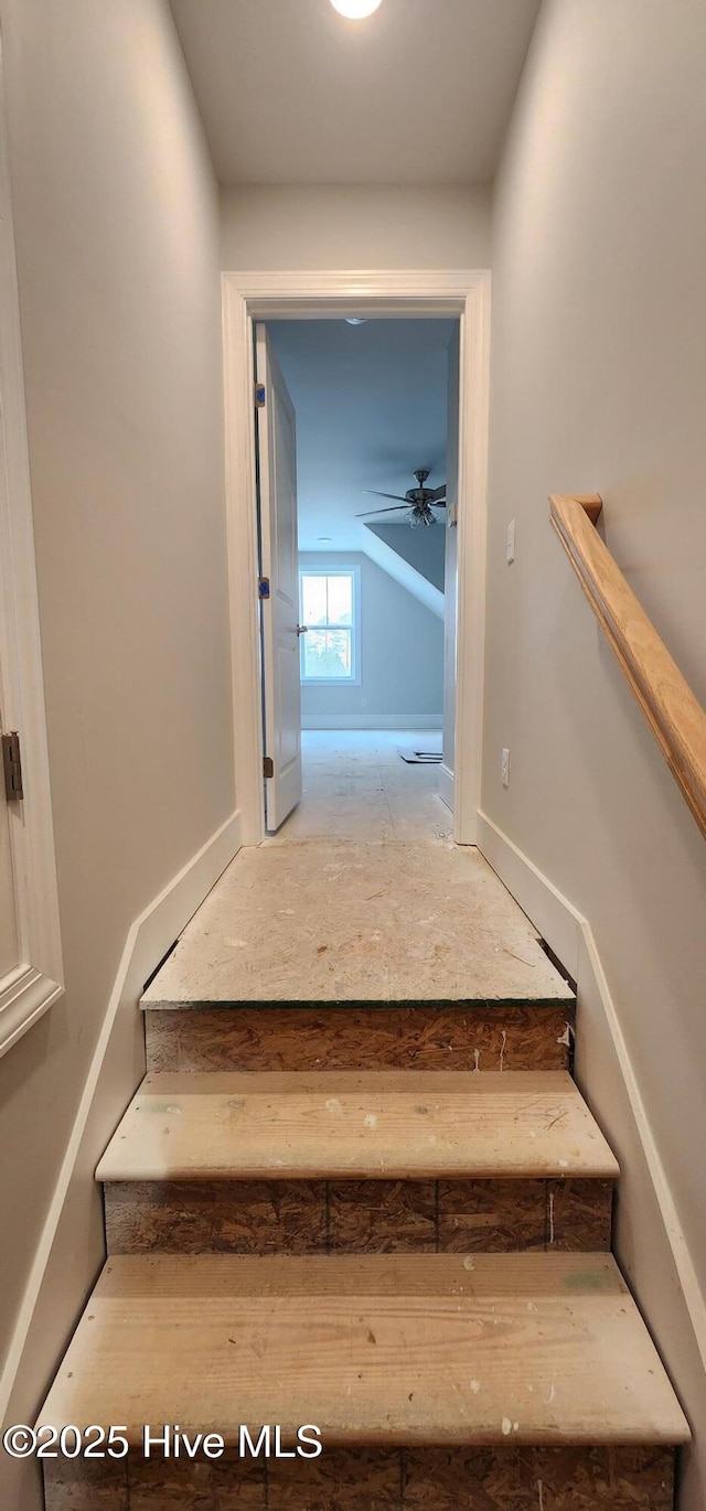 stairway with a ceiling fan and vaulted ceiling