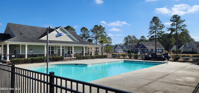 community pool featuring a patio and fence