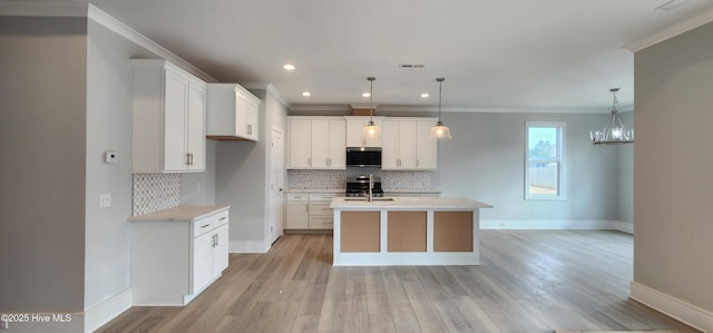 kitchen featuring white cabinets, light wood-style flooring, stainless steel microwave, and range