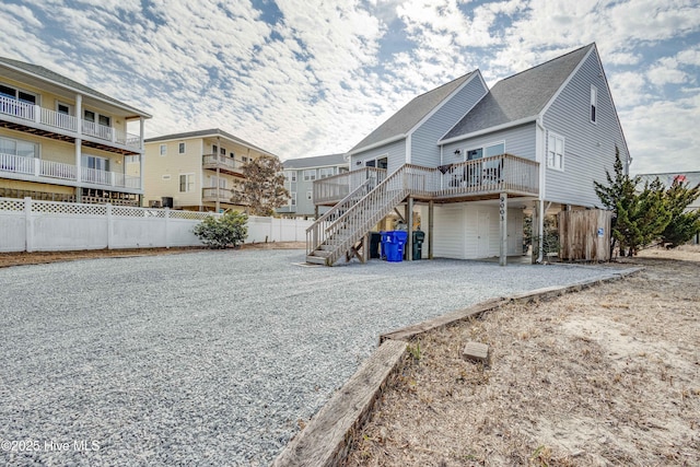 back of property featuring fence, a deck, and stairs