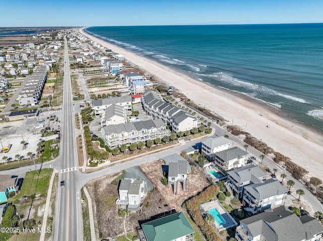 aerial view with a view of the beach, a water view, and a residential view
