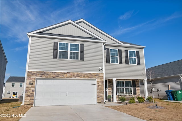 view of front of property featuring an attached garage, stone siding, board and batten siding, and concrete driveway