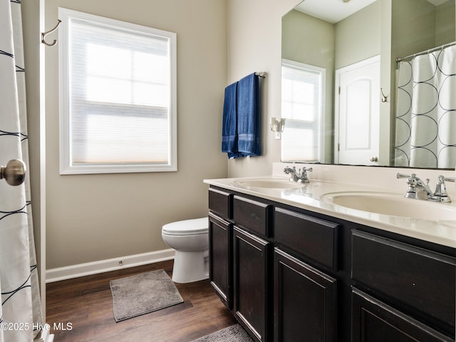 bathroom with a sink, baseboards, and wood finished floors