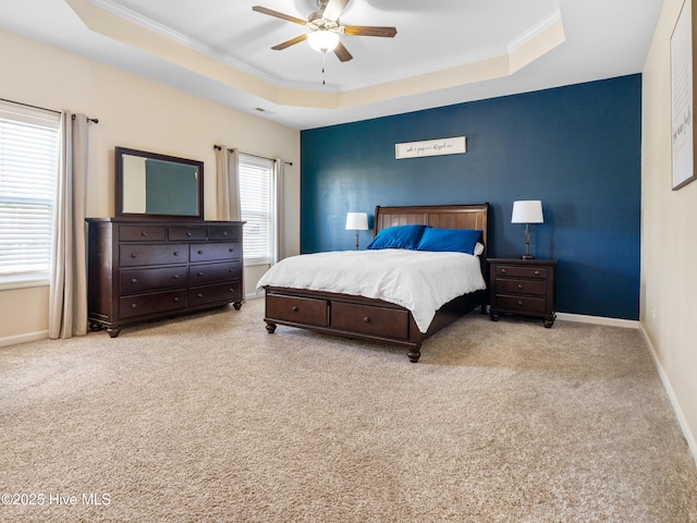 carpeted bedroom with crown molding, ceiling fan, a tray ceiling, and baseboards