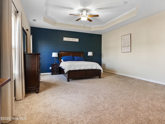 bedroom featuring crown molding, a tray ceiling, carpet, and baseboards