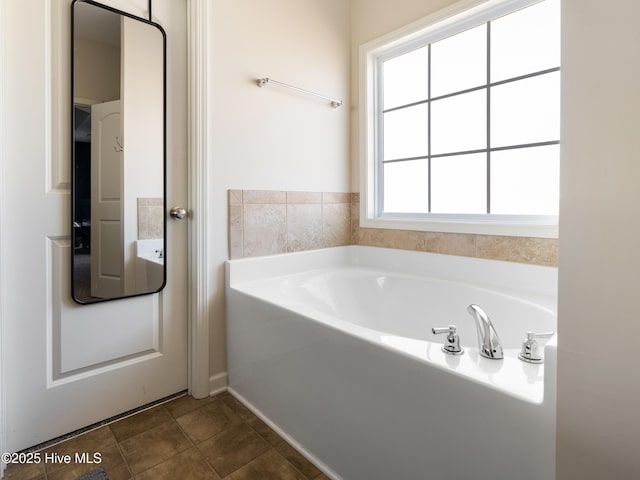 bathroom with a garden tub and tile patterned floors