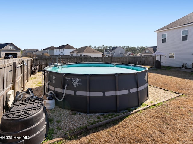 view of swimming pool with a fenced backyard, a residential view, and a fenced in pool