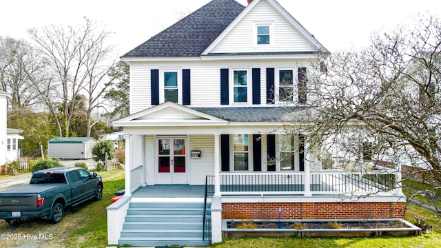 view of front of house featuring covered porch and a shingled roof