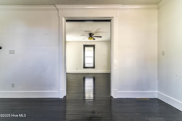 unfurnished room featuring crown molding, ceiling fan, dark wood finished floors, and baseboards