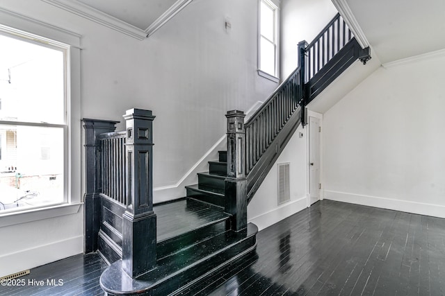 staircase featuring ornamental molding, plenty of natural light, and visible vents