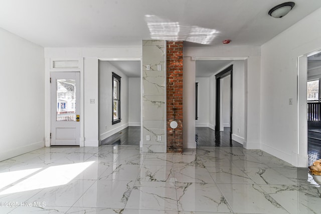 entrance foyer featuring marble finish floor and baseboards