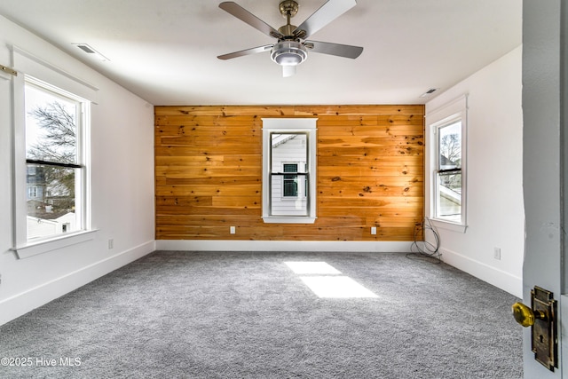 empty room with carpet floors, plenty of natural light, and baseboards