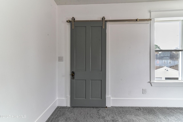 unfurnished room featuring carpet and baseboards