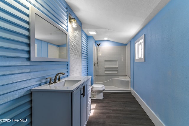 full bath featuring baseboards, a shower, toilet, wood finished floors, and vanity