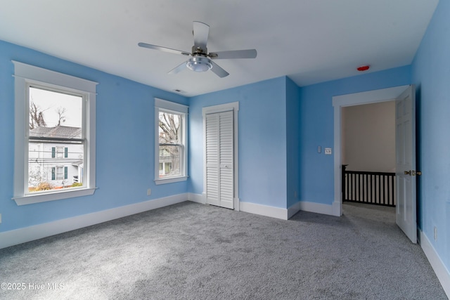 unfurnished bedroom featuring a ceiling fan, a closet, carpet flooring, and baseboards