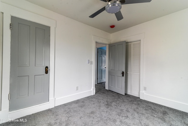 unfurnished bedroom featuring a closet, carpet, a ceiling fan, and baseboards