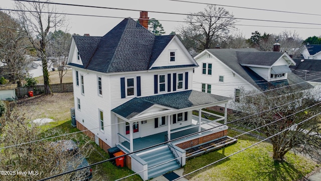 rear view of property featuring fence private yard, a chimney, a porch, and roof with shingles