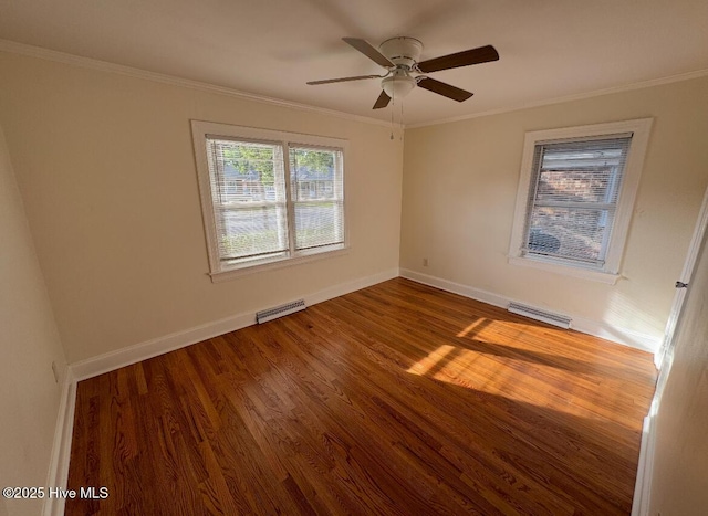 spare room featuring baseboards, visible vents, ceiling fan, wood finished floors, and crown molding