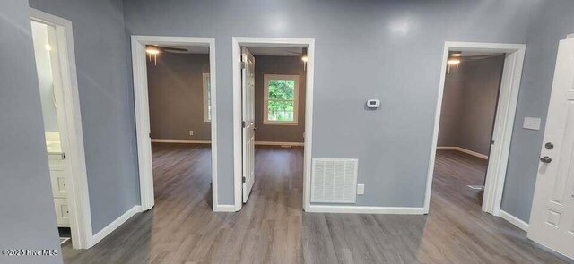 unfurnished room with baseboards, visible vents, and wood finished floors