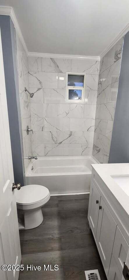 bathroom with shower / tub combination, toilet, visible vents, vanity, and crown molding