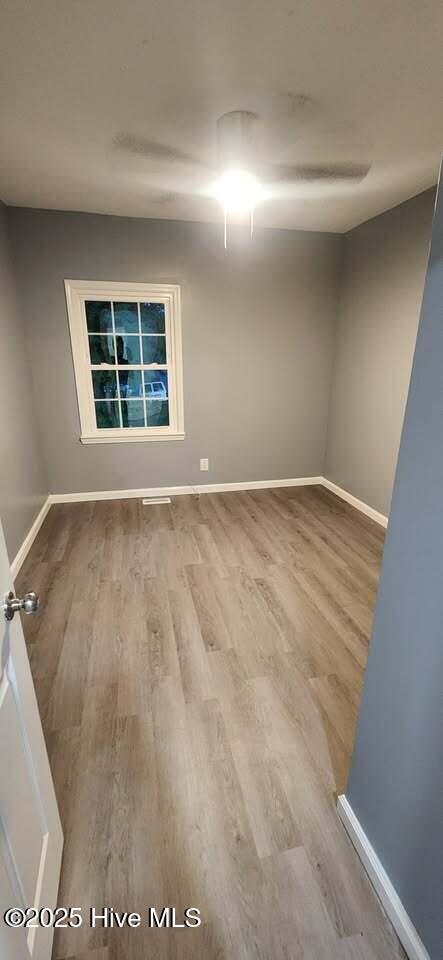 unfurnished room with wood finished floors and baseboards