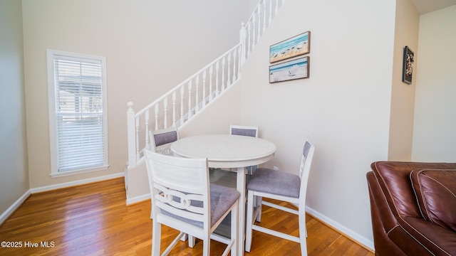 dining area with stairway, wood finished floors, and baseboards