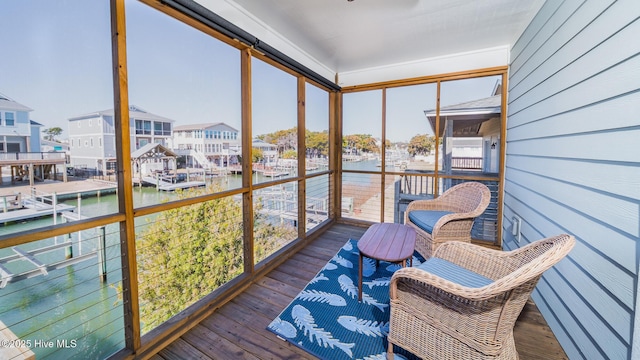 sunroom / solarium featuring a water view and a residential view