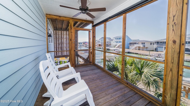 sunroom / solarium featuring a water view, a residential view, and a ceiling fan