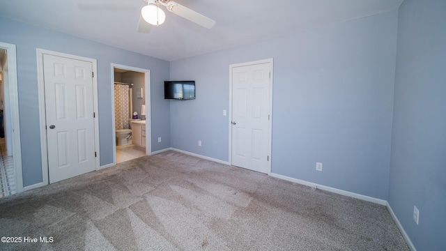 unfurnished bedroom featuring carpet floors, a ceiling fan, baseboards, and connected bathroom