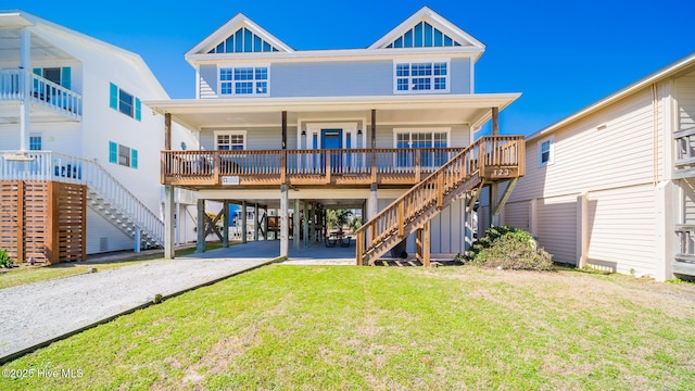 back of house with gravel driveway, covered porch, stairway, and a lawn