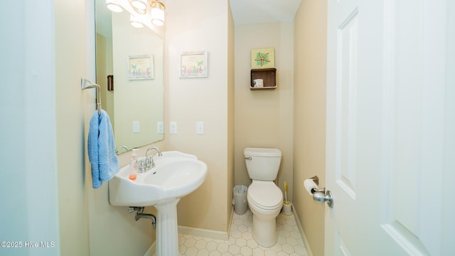 bathroom featuring toilet, tile patterned flooring, and baseboards