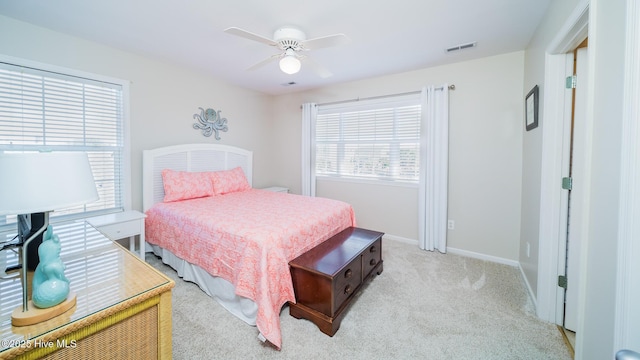 bedroom with light carpet, a ceiling fan, visible vents, and baseboards