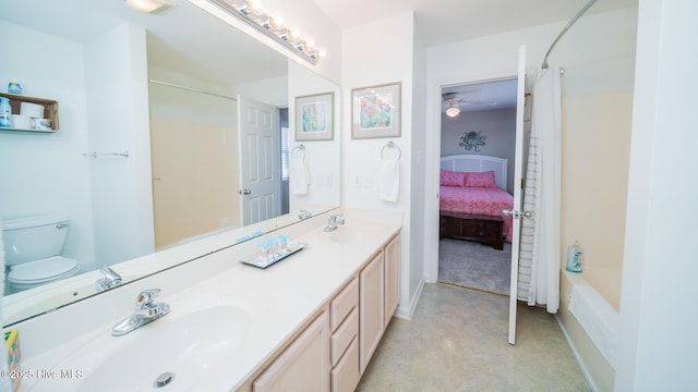 bathroom with double vanity, shower / bath combination with curtain, a sink, and toilet