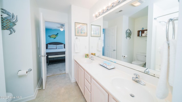 bathroom with visible vents, double vanity, a sink, and toilet