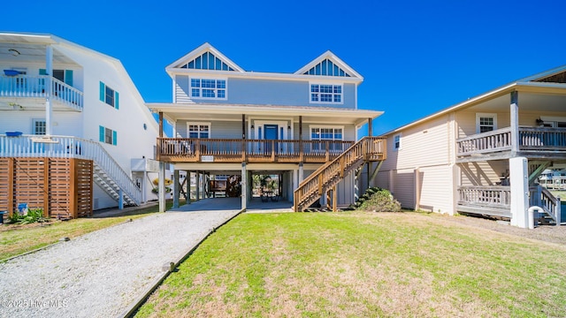 rear view of house with a porch, a lawn, board and batten siding, a carport, and driveway