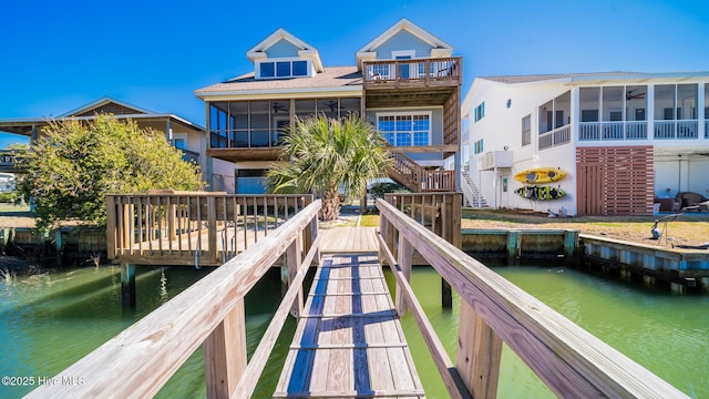 rear view of property with a sunroom and a water view