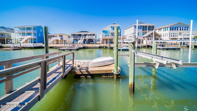 view of dock with a water view and a residential view