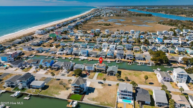 drone / aerial view featuring a view of the beach, a residential view, and a water view