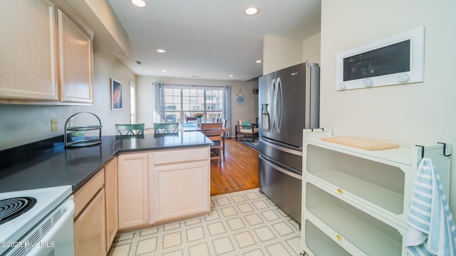 kitchen featuring a peninsula, dark countertops, recessed lighting, and stainless steel fridge with ice dispenser