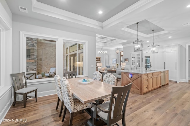 dining space featuring a raised ceiling, visible vents, ornamental molding, a chandelier, and light wood-type flooring