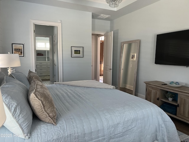 bedroom featuring wood finished floors, visible vents, and baseboards