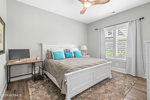 bedroom with baseboards, visible vents, ceiling fan, and wood finished floors