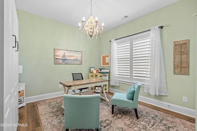 home office with a notable chandelier, visible vents, baseboards, and wood finished floors