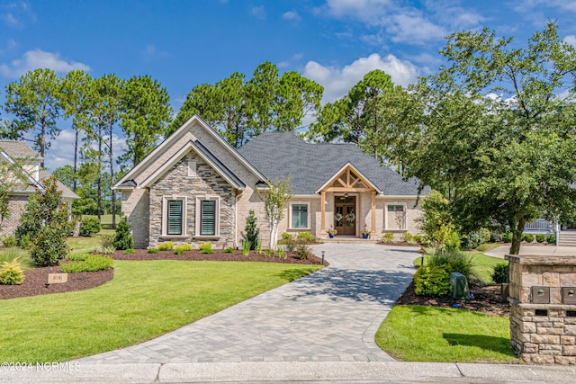 view of front of property with stone siding, decorative driveway, and a front yard