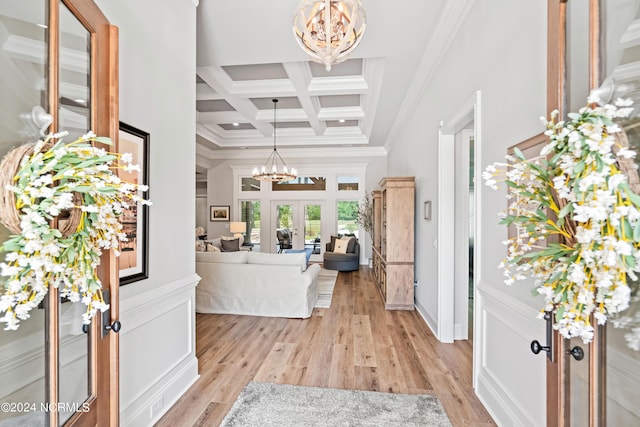 entrance foyer with light wood finished floors, french doors, coffered ceiling, and an inviting chandelier