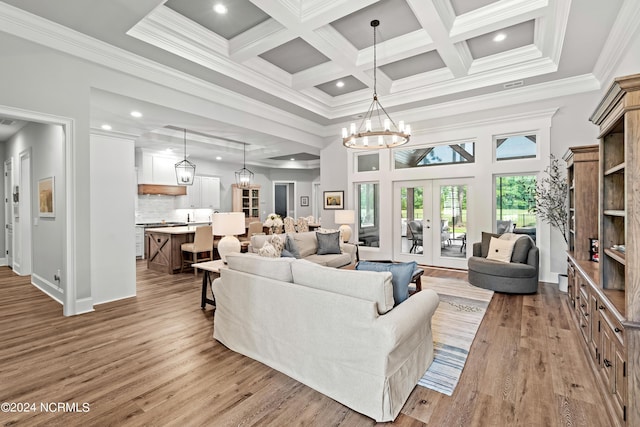 living room featuring light wood-type flooring, an inviting chandelier, beamed ceiling, and french doors