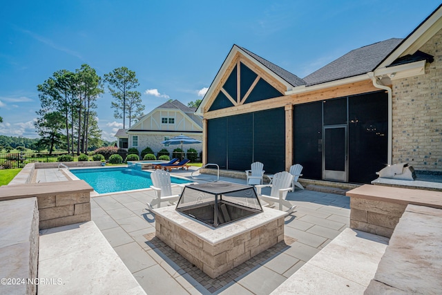 view of pool featuring an outdoor fire pit, a patio area, fence, and a pool with connected hot tub