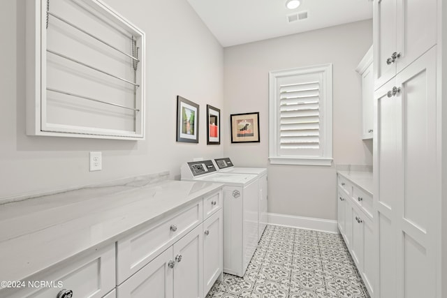 clothes washing area featuring light tile patterned floors, visible vents, baseboards, cabinet space, and washer and clothes dryer